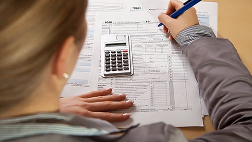 Blonde woman working on taxes © mathrom/Shutterstock.com