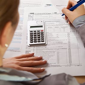 Blonde woman working on taxes © mathrom/Shutterstock.com