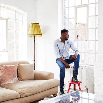 Man leaning against windowsill | Kelvin Murray/Getty Images
