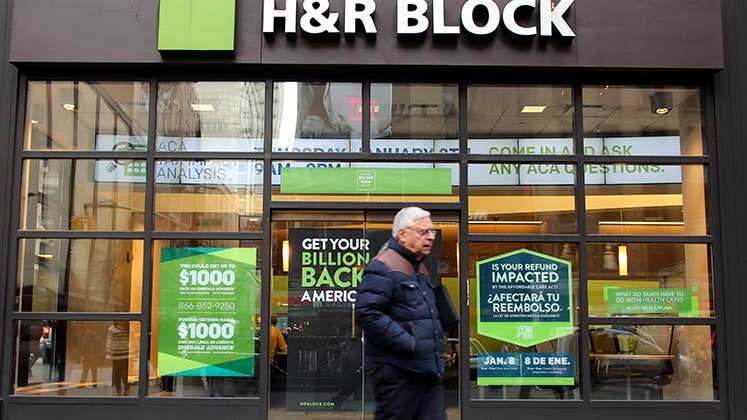 Man walking past storefront of H&R Block | Northfoto/Shutterstock.com