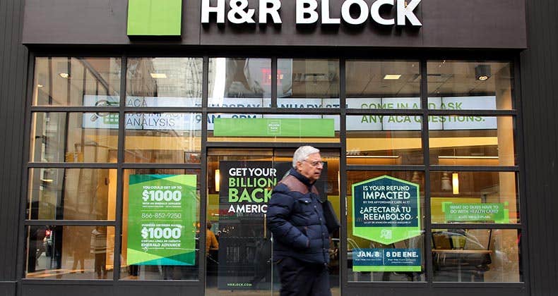 Man walking past storefront of H&R Block | Northfoto/Shutterstock.com