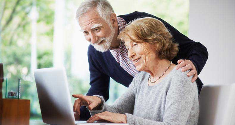 Senior couple browsing laptop at home | Anadolu Agency/Getty Images