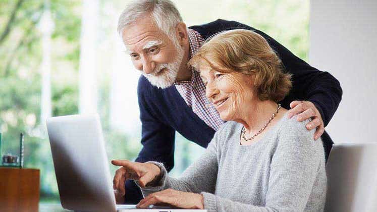 Senior couple browsing laptop at home | Anadolu Agency/Getty Images
