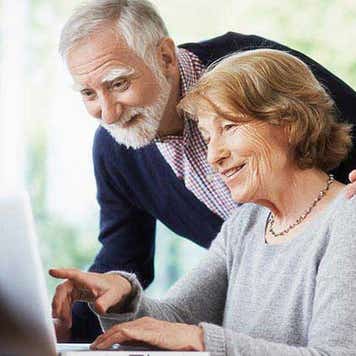Senior couple browsing laptop at home | Anadolu Agency/Getty Images