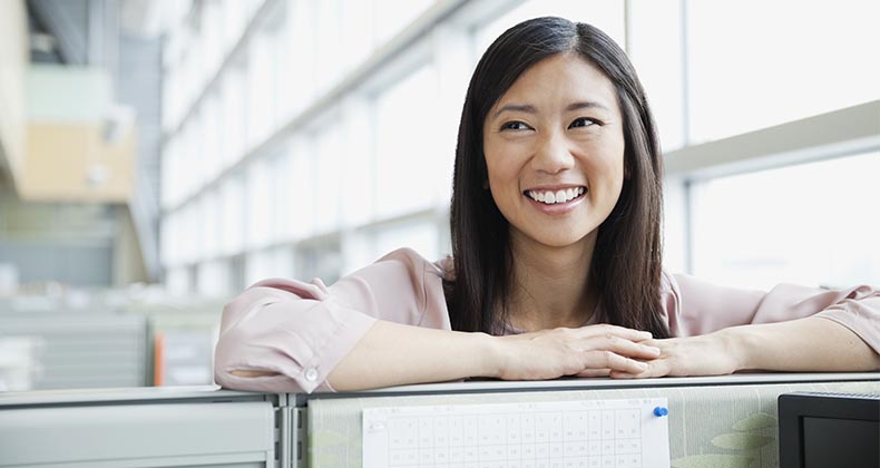 Smiling young woman in work office | Hero Images/Getty Images