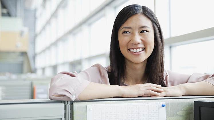 Smiling young woman in work office | Hero Images/Getty Images