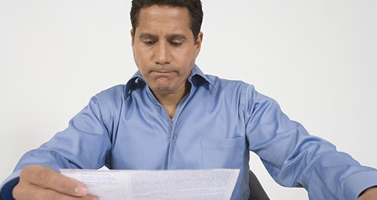 Middle-aged man reading financial document © bikeriderlondon/Shutterstock.com