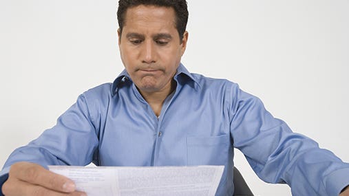 Middle-aged man reading financial document © bikeriderlondon/Shutterstock.com