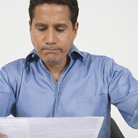 Middle-aged man reading financial document © bikeriderlondon/Shutterstock.com