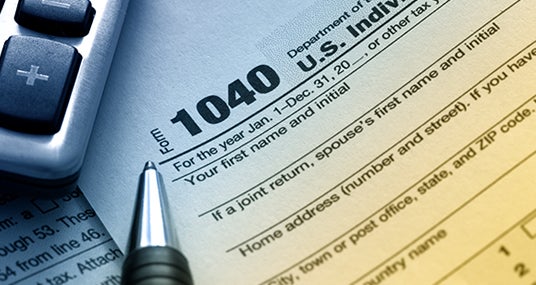 Tax form 1040 in blue and yellow lighting © Robyn Mackenzie/Shutterstock.com