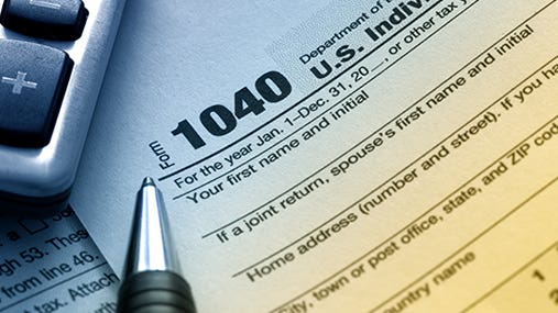 Tax form 1040 in blue and yellow lighting © Robyn Mackenzie/Shutterstock.com