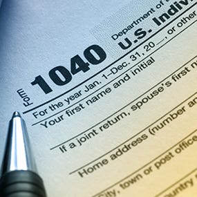 Tax form 1040 in blue and yellow lighting © Robyn Mackenzie/Shutterstock.com