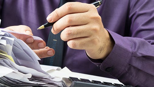 Man working on finances © patpitchaya/Shutterstock.com