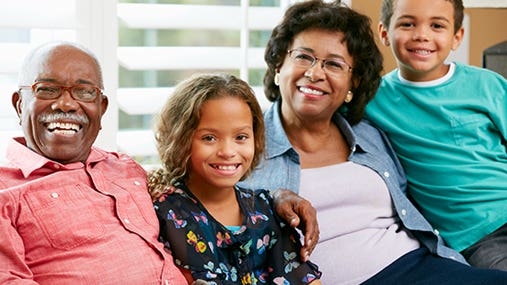 Grandparents and grandchildren sitting on couch © Monkey Business Images/Shutterstock.com