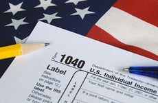 Tax form on United States flag © Maria Dryfhout/Shutterstock.com