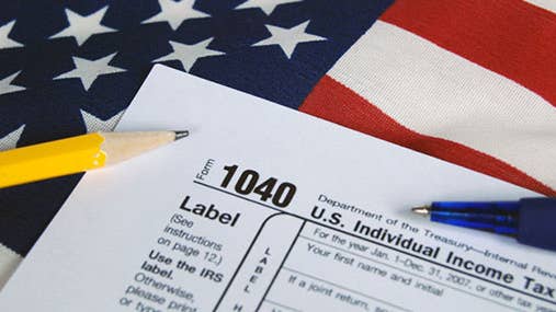 Tax form on United States flag © Maria Dryfhout/Shutterstock.com
