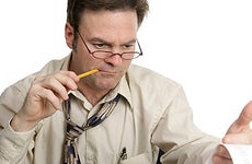 Man doing taxes, pencil in mouth © Fotolia.com