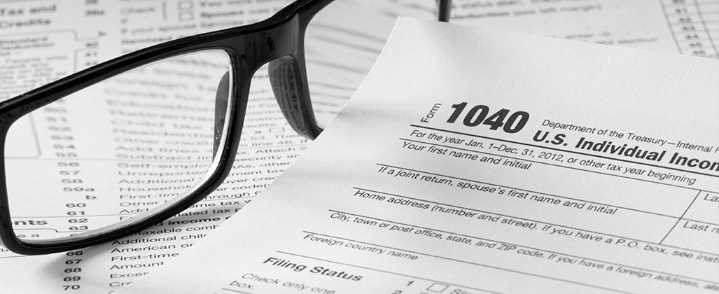 Form 1040 with glasses and pen © topseller/Shutterstock.com