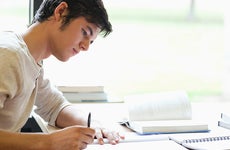 Young man writing at desk © wavebreakmedia/Shutterstock.com