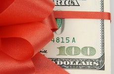 $100 wrapped in red ribbon © Andy Dean Photography/Shutterstock.com