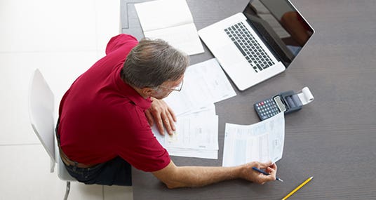 Man doing paperwork © Diego Cervo/Shutterstock.com
