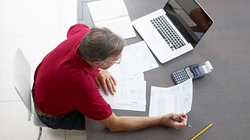 Man doing paperwork © Diego Cervo/Shutterstock.com