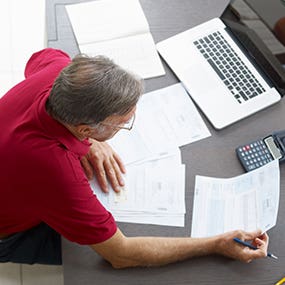 Man doing paperwork © Diego Cervo/Shutterstock.com