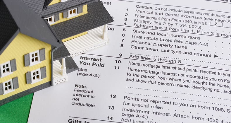 Toy house on tax form © karen roach/Shutterstock.com
