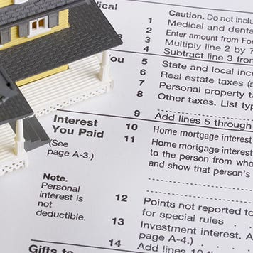 Toy house on tax form © karen roach/Shutterstock.com