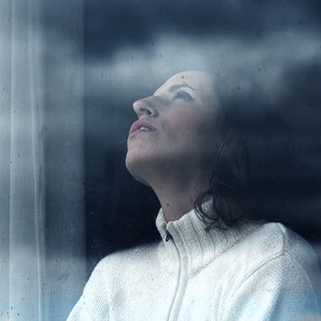 Sad woman looking through the window © Dubova/Shutterstock.com