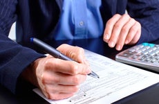 Man in blue jacket filling up tax return form © docent/Shutterstock.com