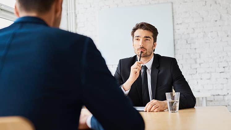 Man in suit, thinking during an interview | baranq/Shutterstock.com