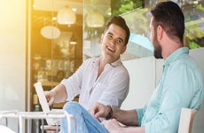Two men sitting outside, laughing | Vasin Lee/Shutterstock.com