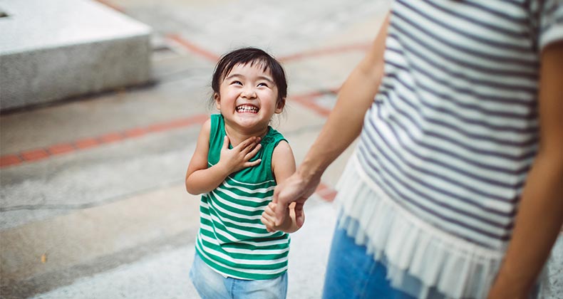 Smiling child holding mother's hand | Images By Tang Ming Tung/Getty Images