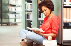 Female college student reading in library