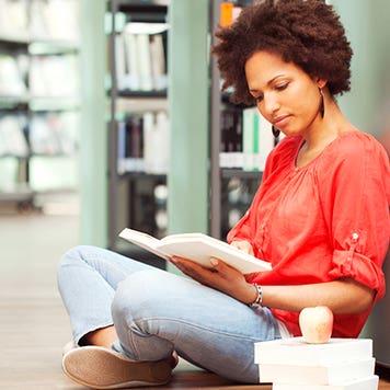 Female college student reading in library