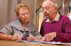 Two seniors looking at their checkbook © iStock
