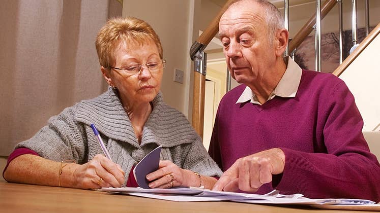Two seniors looking at their checkbook © iStock