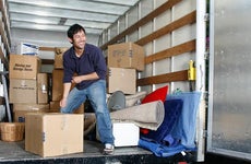 Man happily unloading boxes from boxtruck | John Eder/Getty Images