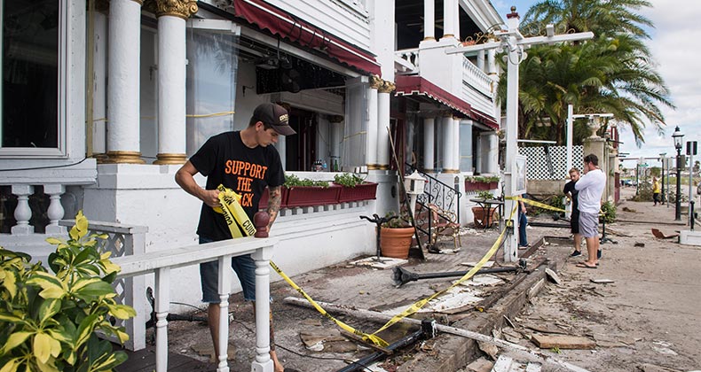 Man removing yellow caution tape from damaged home | The Washington Post/Getty Images