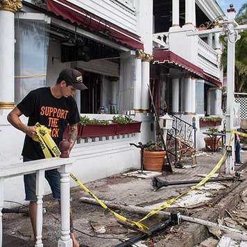 Man removing yellow caution tape from damaged home | The Washington Post/Getty Images