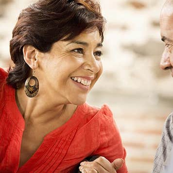 Wife leaning over and talking to husband | Blend Images – Sollina Images/Brand X Pictures/Getty Images