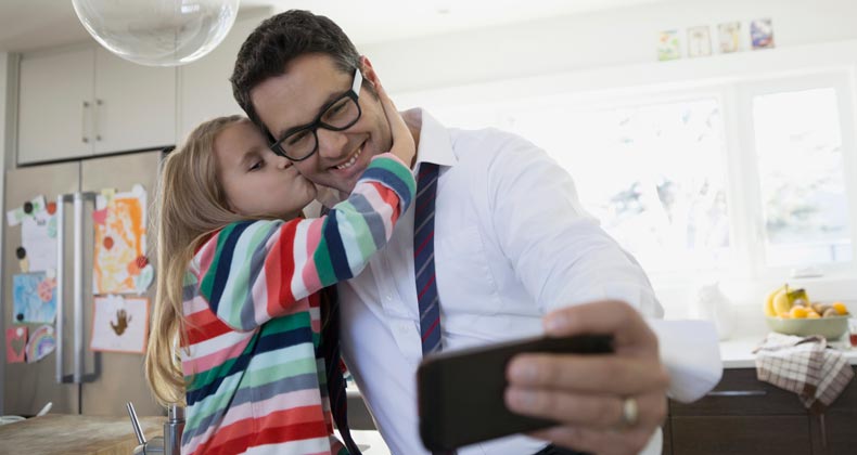 Father taking a selfie with his daughter | Hero Images/Getty Images