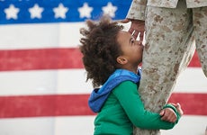 Child hugging military parent's leg | LWA/Dann Tardif/GettyImages