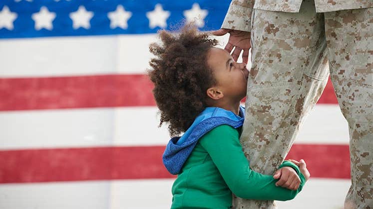 Child hugging military parent's leg | LWA/Dann Tardif/GettyImages