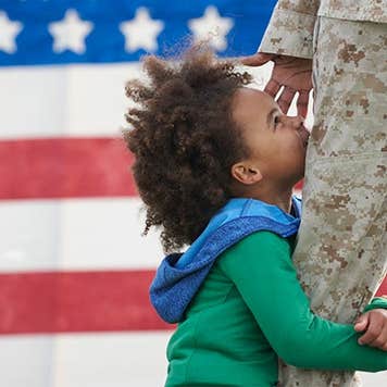 Child hugging military parent's leg | LWA/Dann Tardif/GettyImages
