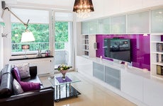Modern apartment living room with purple TV wall | Jacek Kadaj/Getty Images