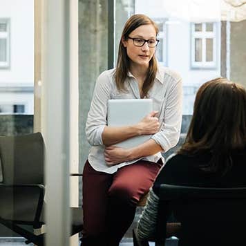 Two colleagues speaking privately | Hinterhaus Productions/Getty Images
