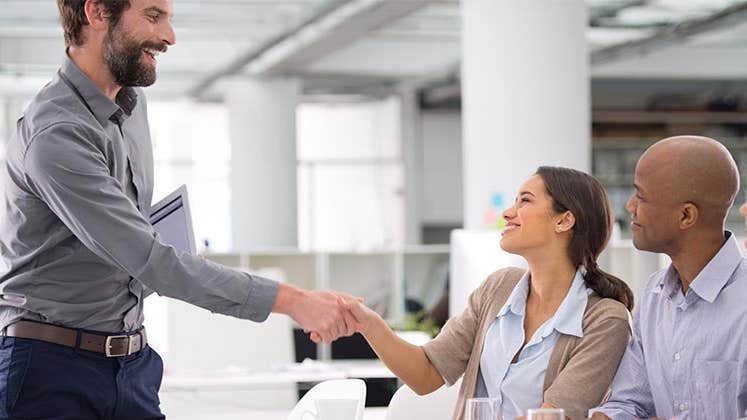 Employees shaking hands | PeopleImages.com/Getty Images