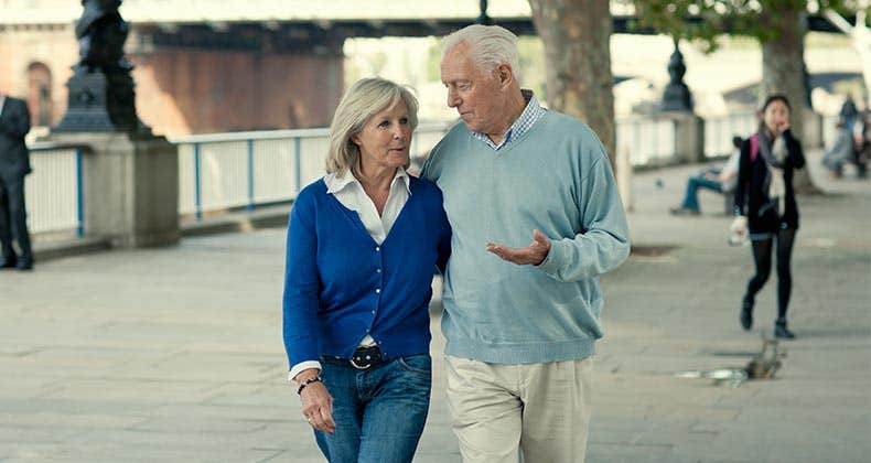 Older couple walking along bridge, talking | VisitBritain/Getty Images